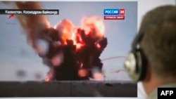 Мужчина смотрит по телевизору прямую трансляцию запуска ракеты-носителя «Протон-М» с Байконура. Ракета упала практически сразу после старта на территории Кызылординской области. 2 июля 2013 года.