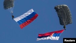 Парашютисты с российским и сербским флагами на совместных учениях военнослужащих двух стран
