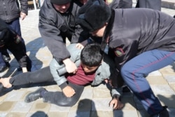 Полиция наразы азаматты ұстап жатқан сәт. Алматы, 1 наурыз 2020 жыл.