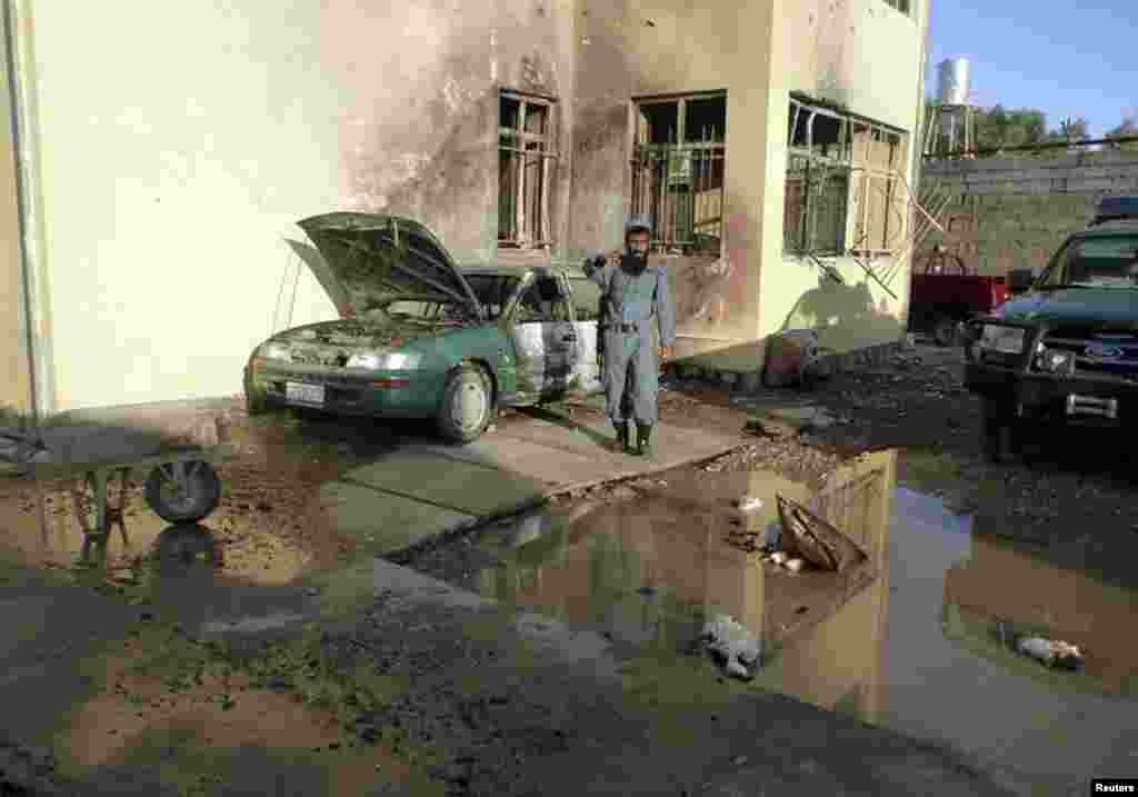 A policeman gestures at the site of the Taliban attack in Farah Province.