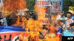 South Korean protesters burn a North Korean flag and portraits of Kim Jong Il in Seoul.