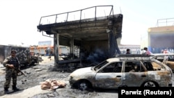 Afghan security forces inspect the site of a suicide attack in the eastern Afghan city of Jalalabad on July 10.