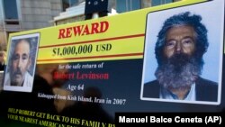 An FBI poster shows a composite image of former FBI agent Robert Levinson, right, of how he would look like now after five years in captivity, and an image, taken from the video, released by his kidnappers, in Washington during a news conference, 