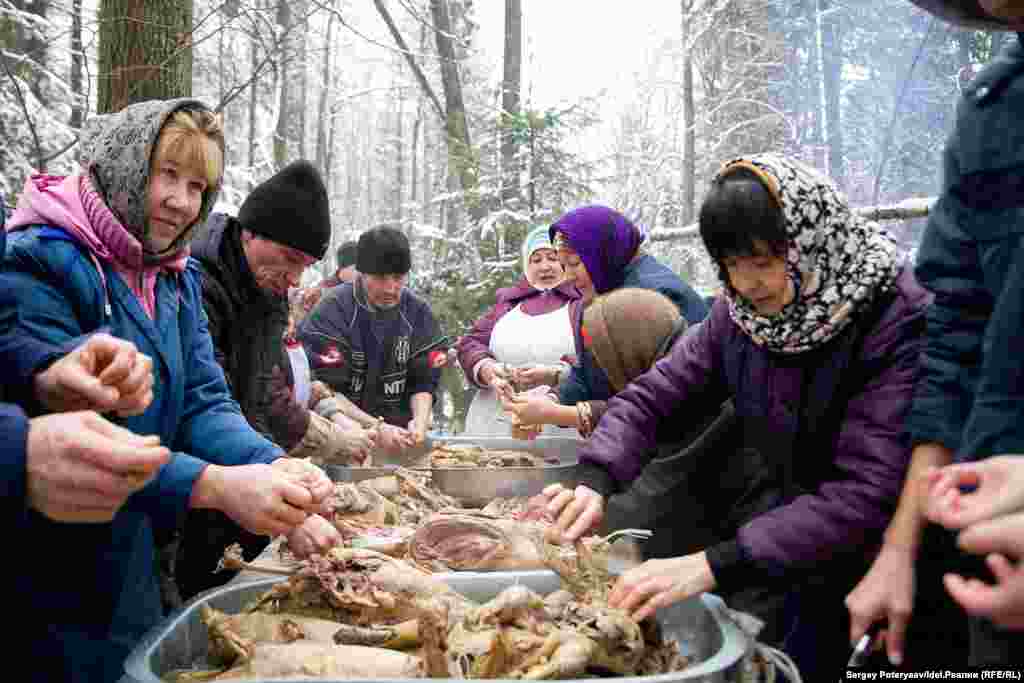 Women carve the meat and cook the dumplings while men tend the fires. It's forbidden to chop down the trees in the sacred grove, so firewood is brought from elsewhere.