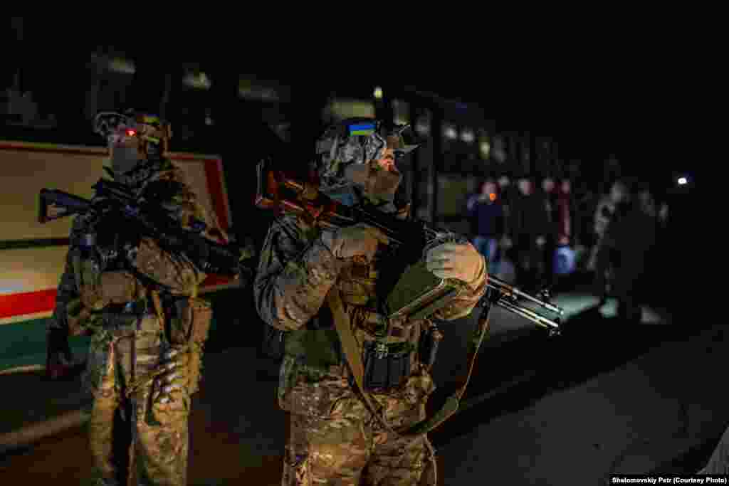Украинский военнослужащий охраняет автобусы с сепаратистами - Ukrainian army servicemen are guarding the bus with prisoners during the largest prisoner exchange in Ukrainian conflict