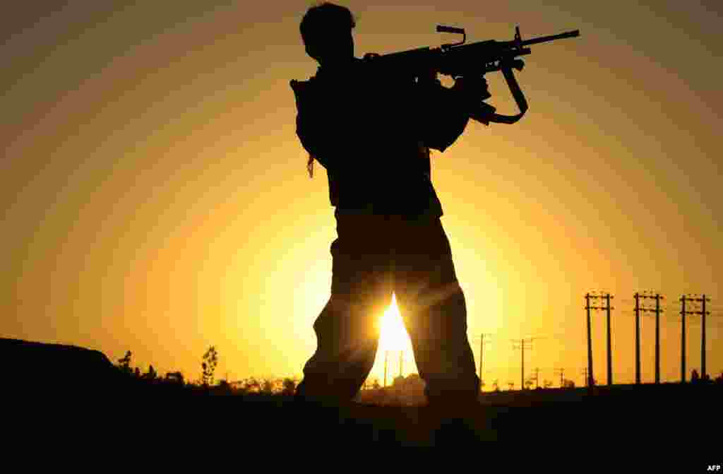 An Afghan policeman points his weapon during an attack on the U.S. Consulate in Herat. (AFP/Aref Karimi)