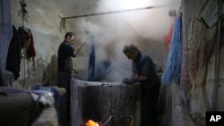  steam rises from a vat of dye as a batch of thread is prepared to be used for hand-woven carpets, in a workshop at the grand bazaar in the ancient city Kashan, Iran.(AP Photo/Vahid Salemi)