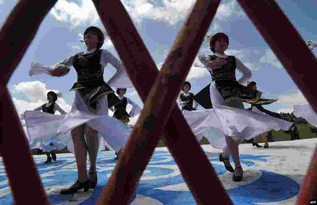 Kyrgyz women wearing traditional costumes perform during a folk festival at Son-Kul Lake, 3,016 meters above sea level, some 350 kilometers from Bishkek. (AFP/ Vyacheslav Oseledko)