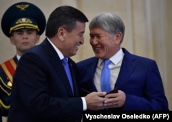 Kyrgyz President Sooronbai Jeenbekov (left) shares a smile at his inauguration ceremony with his predecessor Almazbek Atambaev in 2017. Relations between the two men soured soon afterwards.