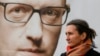 In Kyiv, a woman stands in front of a campaign poster with a portrait of Ukrainian Prime Minister Arseniy Yatsenyuk.