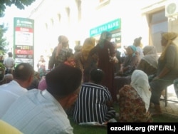 Люди стоят в очереди перед зданием филиала банка Ипак йули в городе Андижане, чтобы получить денежный перевод.