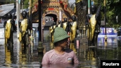 Thailand -- A man wades through a flooded temple in Don Muang district in Bangkok, 27Oct2011