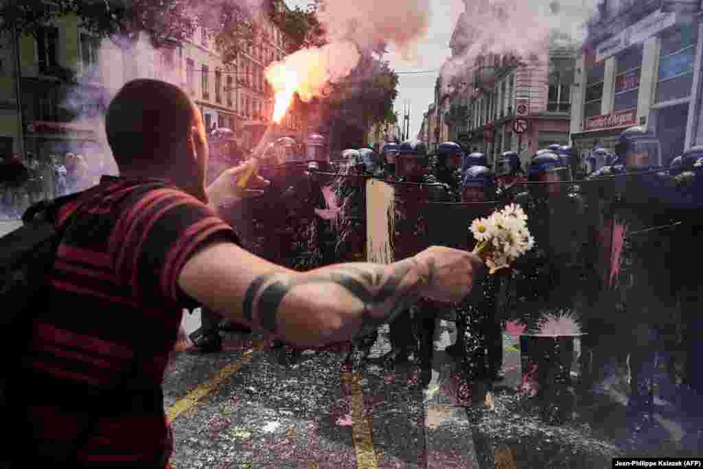 When France was rocked by violent protests against a change to France&#39;s labor laws, AFP&#39;s Jean-Philippe Ksiazek donned a gas mask and helmet to cover protests in Lyon in May. As rocks and paint flew, the seasoned news photographer noticed a bouquet of flowers on the ground that some young female demonstrators had dropped. &ldquo;I bent down to photograph the flowers, then this guy with huge hands picked the flowers up from in front of my camera. Then I stood up and took this photo of him.... We [photographers] are always proud to take a photo that endures a little. We take so many pictures and they are usually forgotten.&quot; Despite the unrest France&#39;s government pushed ahead with the controversial labor legislation, making it easier for&nbsp;employers&nbsp;to hire and fire.