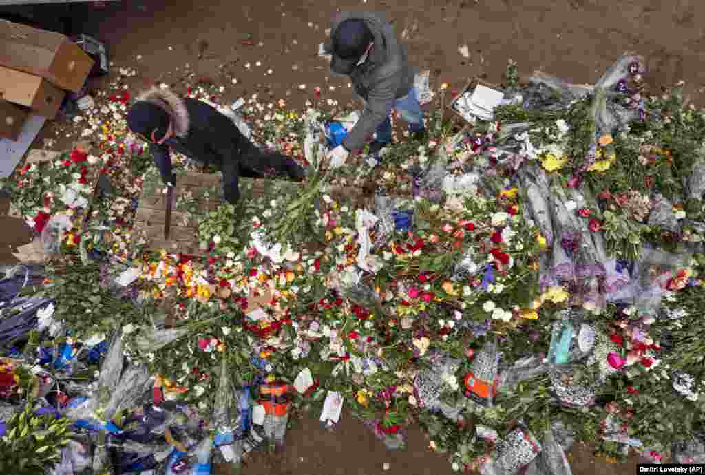 Flower shop employees cut unsold flowers in St. Petersburg, Russia. (AP/Dmitry Lovetsky)