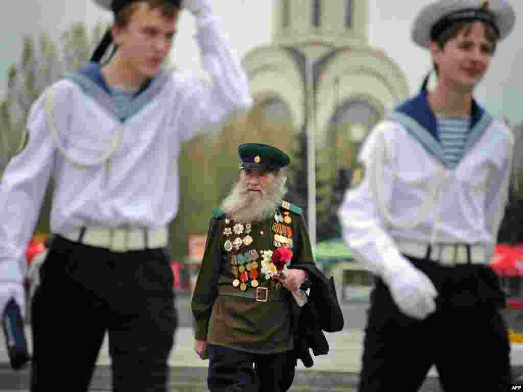 A Russian World War II veteran follows naval cadets at a war memorial in Moscow ahead of the country's Victory Day on May 9 Photo by Alexander Nemenov for AFP. 