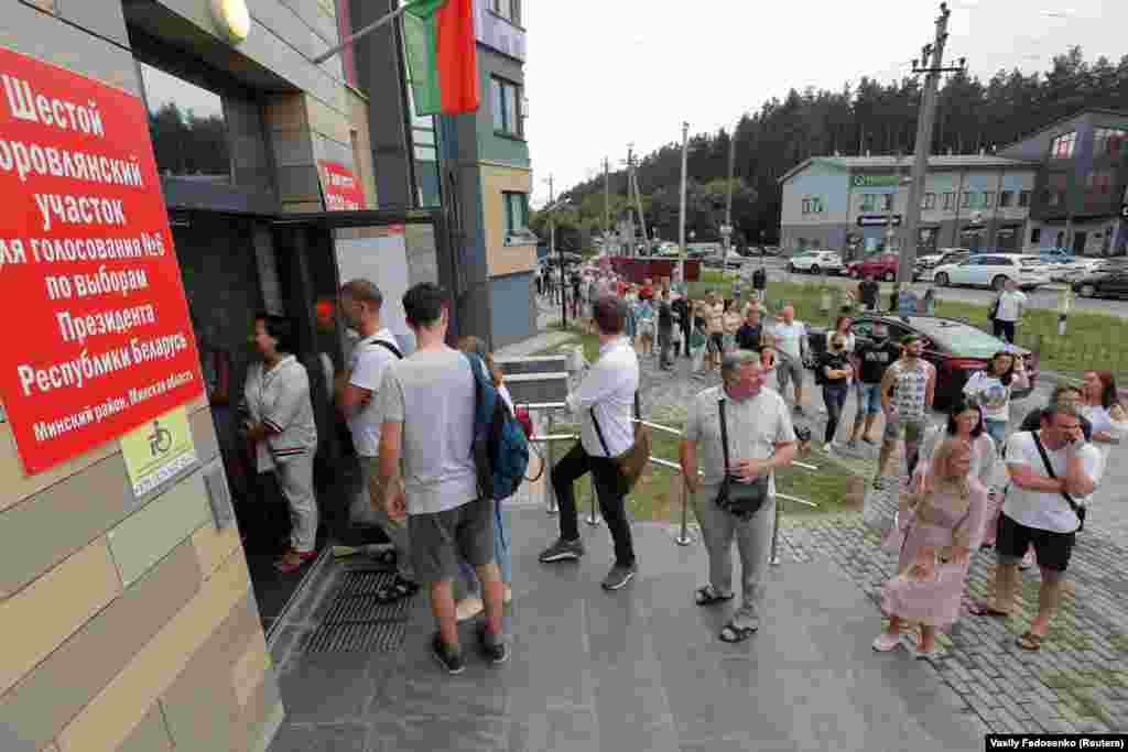 People stand in line outside a polling station in&nbsp;Borovlyany to cast their votes.