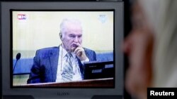 Mejra Dzogaz watches the TV broadcast of the court proceedings of former Bosnian Serb General Ratko Mladic at her home in Potocari, Bosnia. Mejra's husband, three sons, and a grandson were killed during the Srebrenica massacre in 1995.