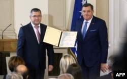 Milorad Dodik (D), drži potpisanu izjavu zakletve, tokom ceremonije predsjedničke inauguracije u Predsjedništvu BiH u Sarajevu 20. novembra 2018.