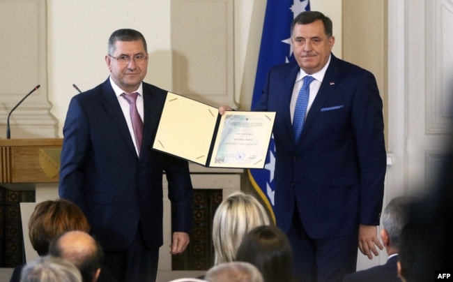 Milorad Dodik (D), drži potpisanu izjavu zakletve, tokom ceremonije predsjedničke inauguracije u Predsjedništvu BiH u Sarajevu 20. novembra 2018.