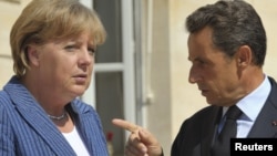 French President Nicolas Sarkozy (right) and German Chancellor Angela Merkel before their meeting at the Elysee Palace in Paris on August 16.