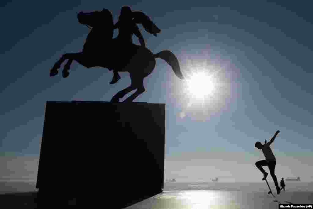 A skateboarder practices next to a modern bronze statue of Alexander the Great in the northern port city of Thessaloniki. (AP/Giannis Papanikos)