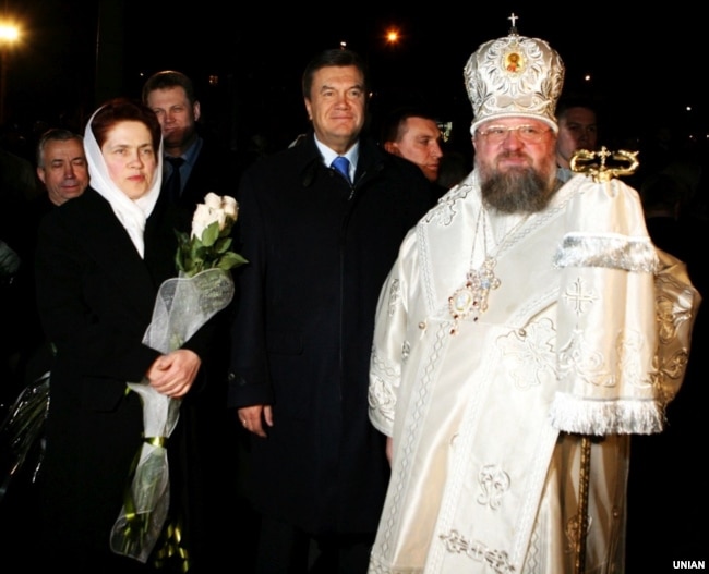 Тодішній прем’єр-міністр України Віктор Янукович з дружиною Людмилою та митрополит Донецький і Маріупольський Ілларіон (Роман Шукало) у кафедральному Свято-Преображенському соборі в Донецьку, 7 квітня 2007 року