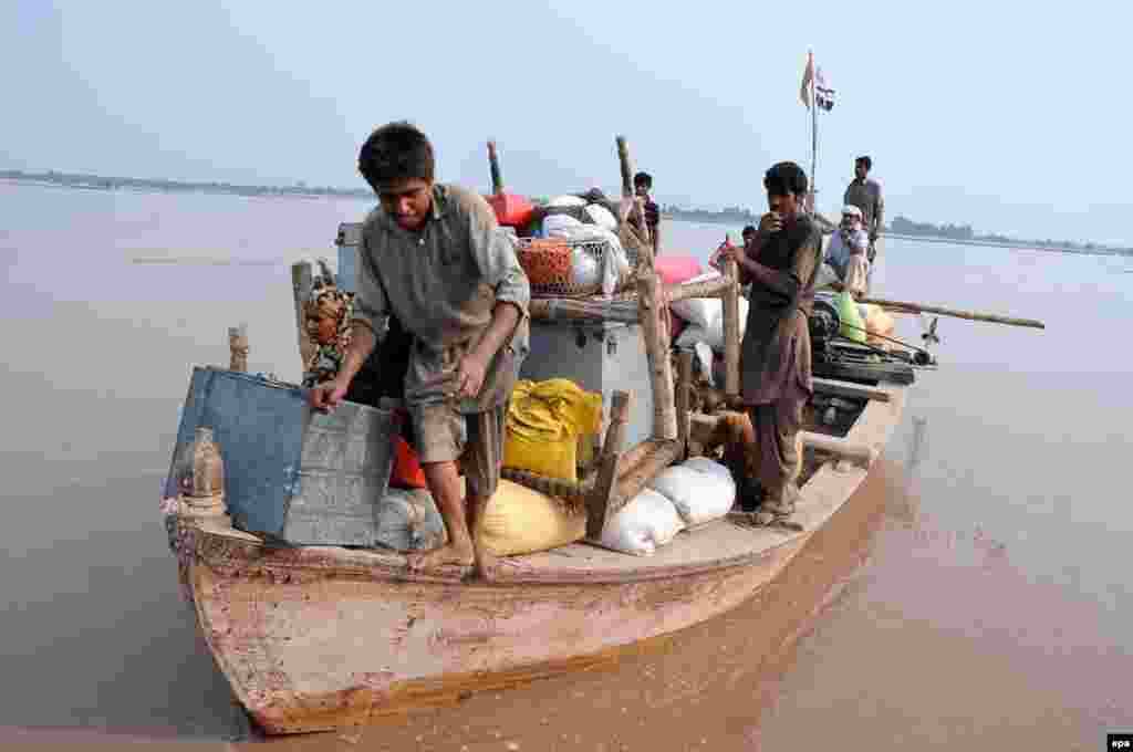 Workers from the Falah-e-Insaniyat Foundation, the relief wing of the banned Pakistan-based charity Jamaat-ud-Dawa (JuD), evacuate people to higher ground on the outskirts of Multan.