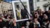 Варшава. Участники демонстрации в память погибших президента Леха Качиньского и его супруги держат их портрет в траурной рамке