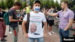 An opposition supporter, wearing a protective face mask and a T-shirt with a modified image of Russian President Vladimir Putin, attends a protest against the constitutional amendments in central Moscow on July 1.