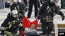 Спасатели несут раненного в результате аварии в метро пассажира. Москва, 15 июля 2014 года.