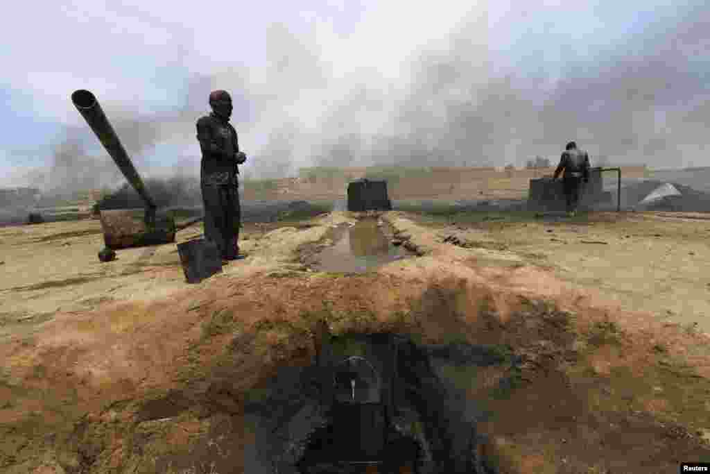 Men work at a makeshift oil refinery site in the Kurdish town of Al-Qahtaniya in Syria. (Reuters/Rodi Said)