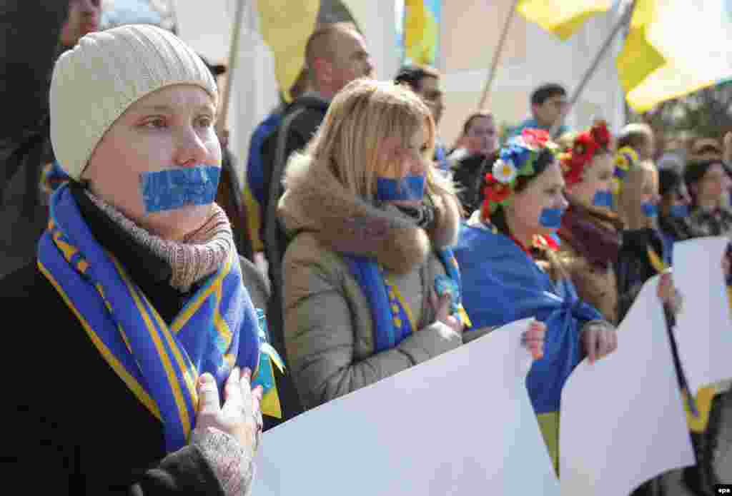 Учасниці акції, представниці руху &laquo;Жінки Криму за МИР&raquo;, провели в Сімферополі мовчазну акцію на підтримку свободи слова. Дівчата заклеїли собі роти синьою стрічкою, а в руках тримали чисті плакати без єдиної літери. 13 березня 2015 року