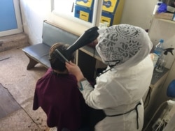 Мастер стрижет клиента в парикмахерской на второй день после разрешения работать. 5 мая 2020 года.