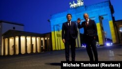 Эммануэль Макрон ва Олаф Шольц Украина байроғи рангларига бўялган Бранденбург дарвозаси фонида, Берлин, 2022 йил 9 майи