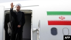 President Hassan Rohani waves before entering an airplane upon his departure to the United States to attend the UN General Assembly, at Tehran's Mehrabad Airport, September 23, 2013