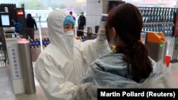 Unei călătoare îi este verificată temperatura după sosirea în gara Xianning, un oraș din apropierea Wuhan, cel mai afectat de noul virus. 24 ianuarie 2020