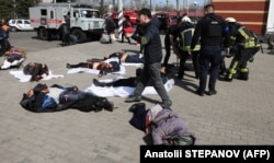 Українські військовослужбовці та рятувальники допомагають пораненим внаслідок ракетного удару російських військових по залізничному вокзалу в Краматорську, 8 квітня 2022 року