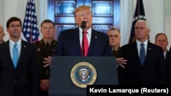 U.S. President Donald Trump delivers a statement about Iran flanked by U.S. Secretary of Defense Mark Esper (far left), Vice President Mike Pence (far right) and military leaders in the Grand Foyer at the White House in Washington on January 8. 