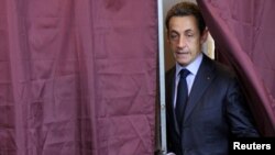 French President Nicolas Sarkozy leaves a Paris polling booth on March 21.