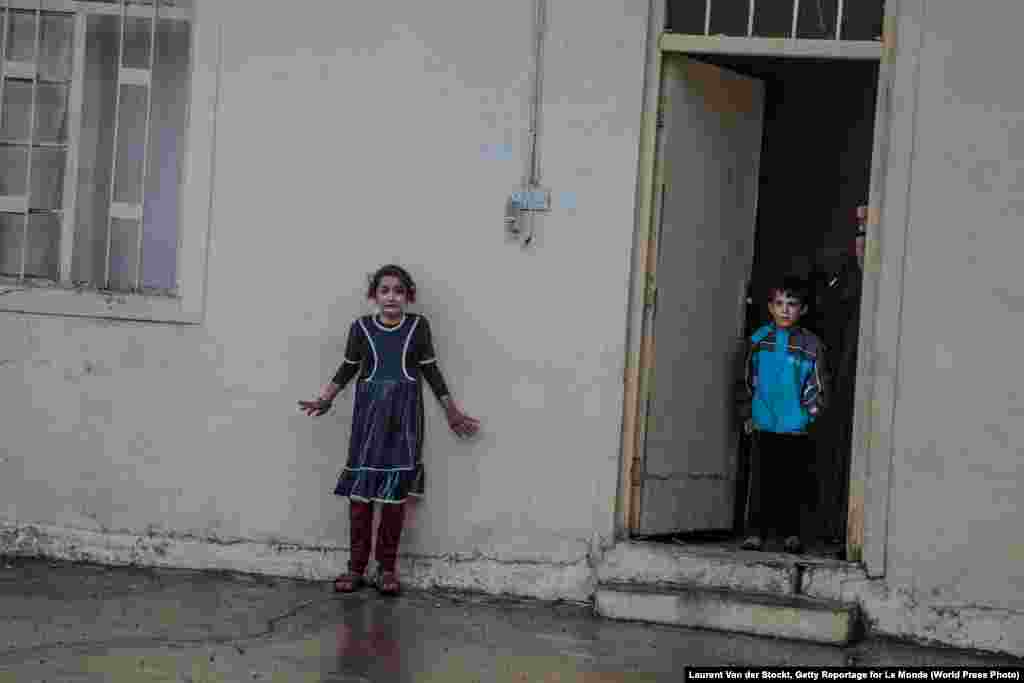 Children wait as Iraqi Special Operations Forces search houses in Gogjali, an eastern district of Mosul, looking for Islamic State militants, equipment, and evidence, on November 2, 2016.&nbsp; General News -- First Prize, Singles (Laurent Van der Stockt, Getty Reportage for Le Monde)