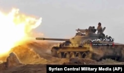 Танк армии Башара Асада ведет огонь по позициям джихадистов под городом Абу-Кемаль. 8 ноября