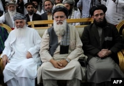 Former Islamist warlord, Abdul Rasul Sayyaf (C) sits with his two vice-presidential candidates, Mohammad Ismail Khan (L) and Abdul Wahab Erfan (file photo)