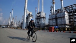An Iranian oil worker rides his bicycle at a Tehran oil refinery. (file photo)