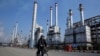 FILE photo- In this Dec. 22, 2014 photo, an Iranian oil worker rides his bicycle at the Tehran oil refinery.