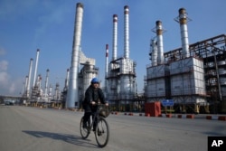 An Iranian oil worker rides his bicycle at a Tehran oil refinery. (file photo)