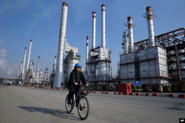 An Iranian oil worker rides his bicycle at a Tehran oil refinery. (file photo)
