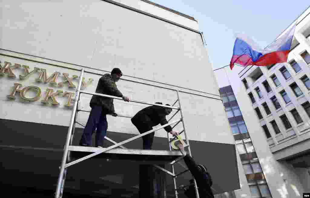 Ukraine - Workers remove letters from a sign on Crimea's Regional Parliament building in Simferopol, Crimea, Ukraine, 18 March 20144