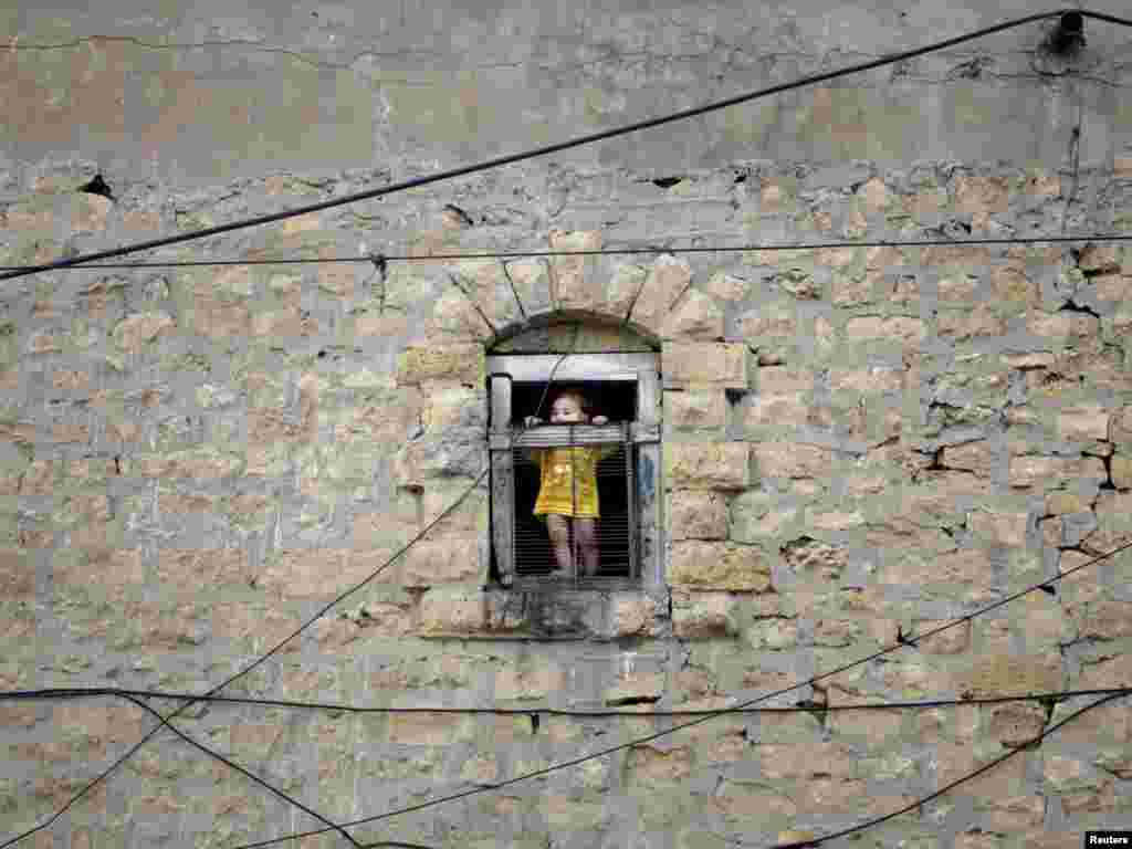 A boy looks at power lines outside a window of a building built in the British Raj era during a power outage in Karachi on May 27. Photo by Akhtar Soomro for Reuters