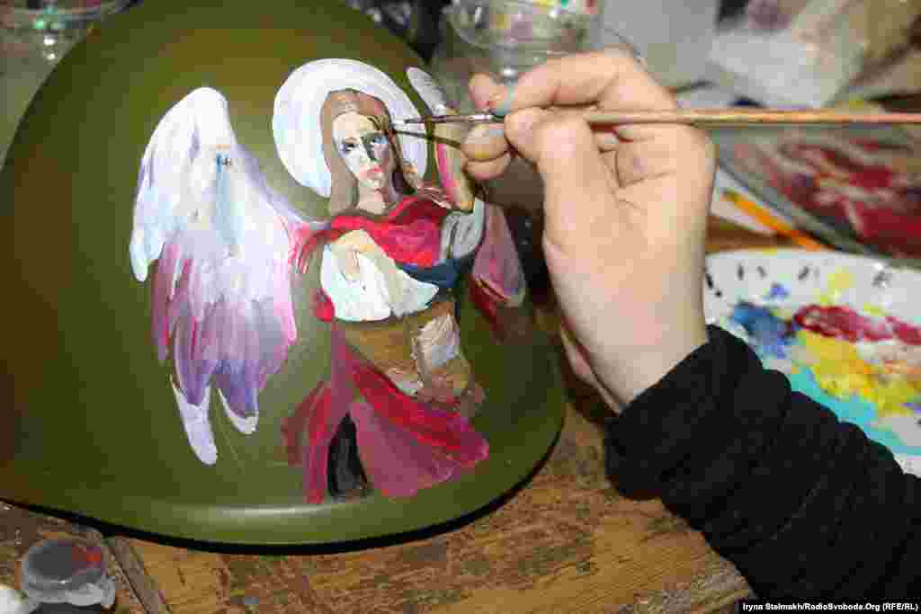 Художниця зображує архангела Михаїла на одному з шоломів в Українському домі