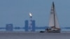 Un iaht trece pe lângă flacăra de gaz din golful Porovaia, regiunea Leningrad, Rusia, 26 august 2022